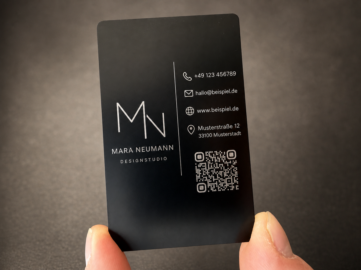 Schwarze Metallvisitenkarte aus Aluminium mit silberfarbener Lasergravur und Musterkontaktdaten
